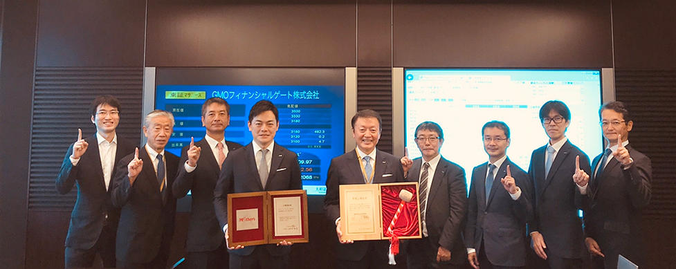 大和証券本社にて上場記念品を受け取った様子